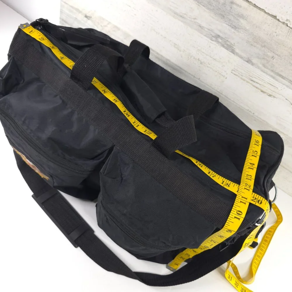 VINTAGE HARLEY DAVIDSON AN AMERICAN LEGEND BLACK DUFFLE BAG WITH SHOULDER STRAP.